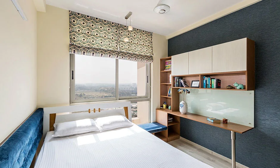 Kids' bedroom in white and royal blue with a tufted bed backrest.