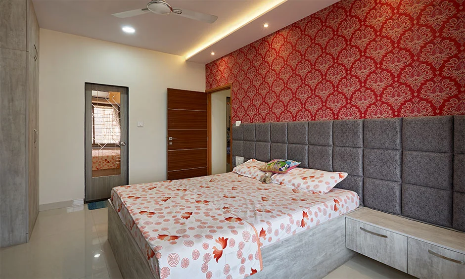 Upholstered headboard, designer wallpaper and oak-finished laminate create a classic bedroom.