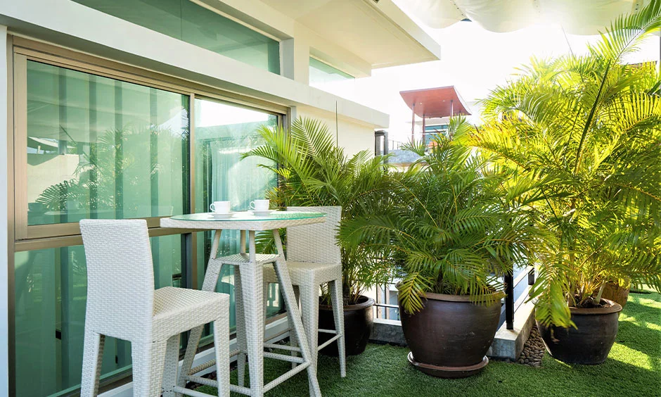 Bar-height wicker seating keeps the artificial grass clear across this rooftop terrace.