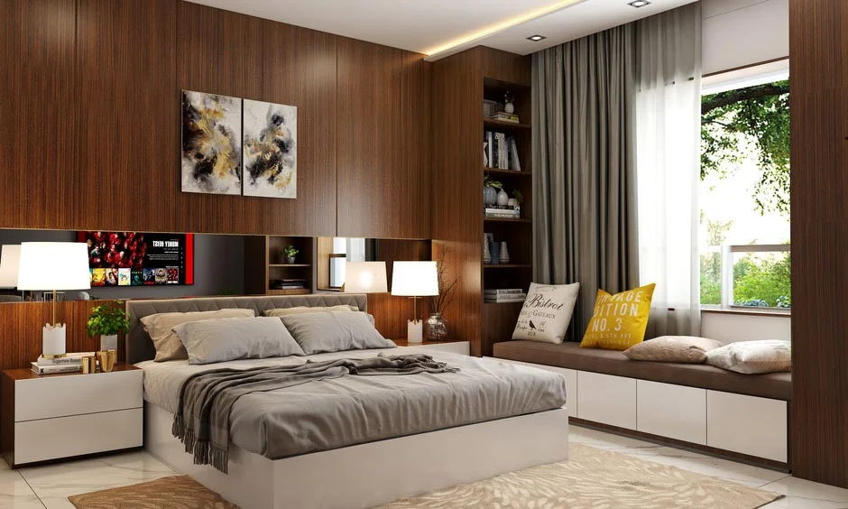 A wood-panelled bedroom with a bookshelf and storage daybed shows 1 BHK bedroom interior cost in Pune.